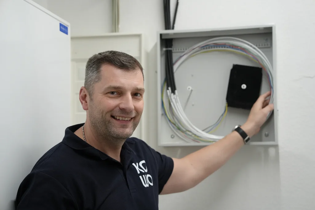 KOWO-Techniker Michael Reumschüssel zeigt, wie Glasfaser im Haus verteilt wird.